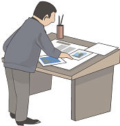 Man studying newspapers on table